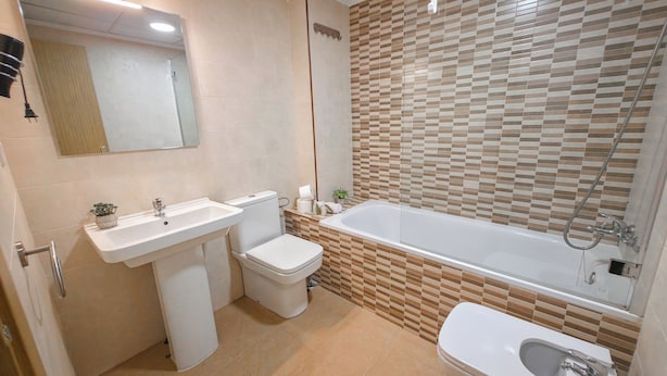 Un baño moderno con inodoro, lavamanos y bañera.