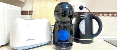 A kitchen with a white toaster, a Krups coffee maker, and a Mondial SmartHot kettle.
