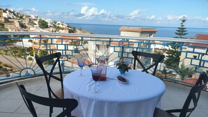 A round table with a white tablecloth, two chairs, a glass of red drink, a small plate with nuts, and a vase with flowers. - Charming seaside villa for 11 people with private pool and fireplace (Tabarka)