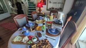 A dining table set with various dishes and drinks, surrounded by chairs. - Charming seaside villa for 11 people with private pool and fireplace (Tabarka)