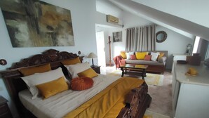 Ein Schlafzimmer mit einem Holzbett, einer Couch und einem Essbereich.