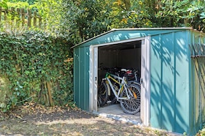 A green shed with a bicycle inside. - Gîte Mélany for 4 Guests (Chargé)