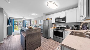 Una cocina moderna con armarios blancos, electrodomésticos de acero inoxidable y una isla grande.