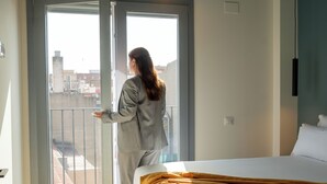 A hotel room with a bed, a window, and a balcony. - Sun & Moon Aparthotel (El Prat de Llobregat)