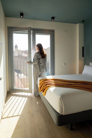 A hotel room with a bed, a window, and a balcony. - Sun & Moon Aparthotel (El Prat de Llobregat)
