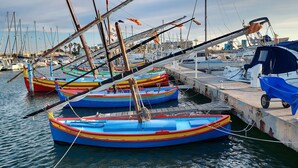A marina with several colorful boats docked at the pier. - 2-bedroom apartment with air conditioning and a terrace—sleeps 4—beach and Christmas village within walking distance (Le Barcarès)