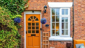 A brick building with a yellow door marked "25" and a white window. - Beautiful Cozy Cottage Home in Sandbach, Sleeps 4! (Cheshire East)