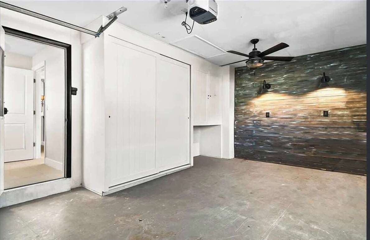 Une pièce avec une porte blanche, un ventilateur de plafond et un mur à texture.
