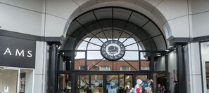 The entrance to West Orchards Centre with a large circular sign above the doors.
