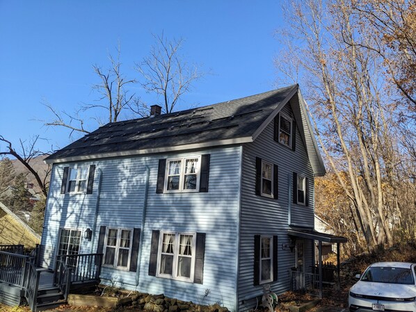 A two-story house with a steep roof, multiple windows, and a front porch. - Charming Retreat by Mass MoCA (North Adams)