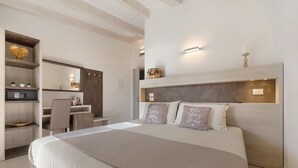 A modern bedroom with a large bed, a desk, and a mirror. - Eco del Garda – Room 306 – with Covered Terrace and Lake View (Tenno)