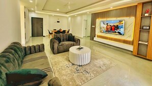 Una sala de estar moderna con un sofá, una mesa de centro redonda y una televisión.