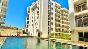 Un moderno edificio de apartamentos con una piscina al frente.