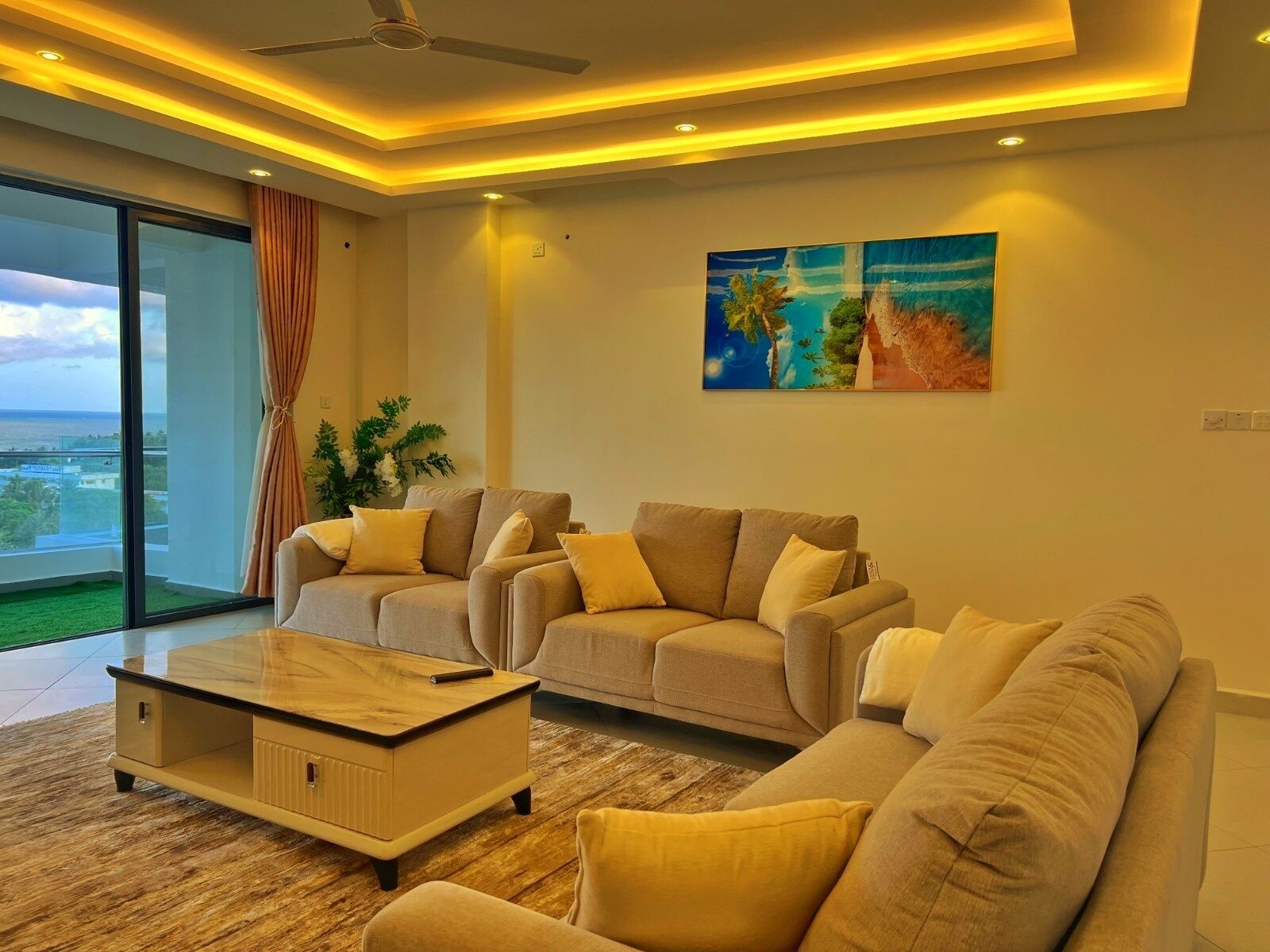 A modern living room with a sofa set, a coffee table, and a painting on the wall.
