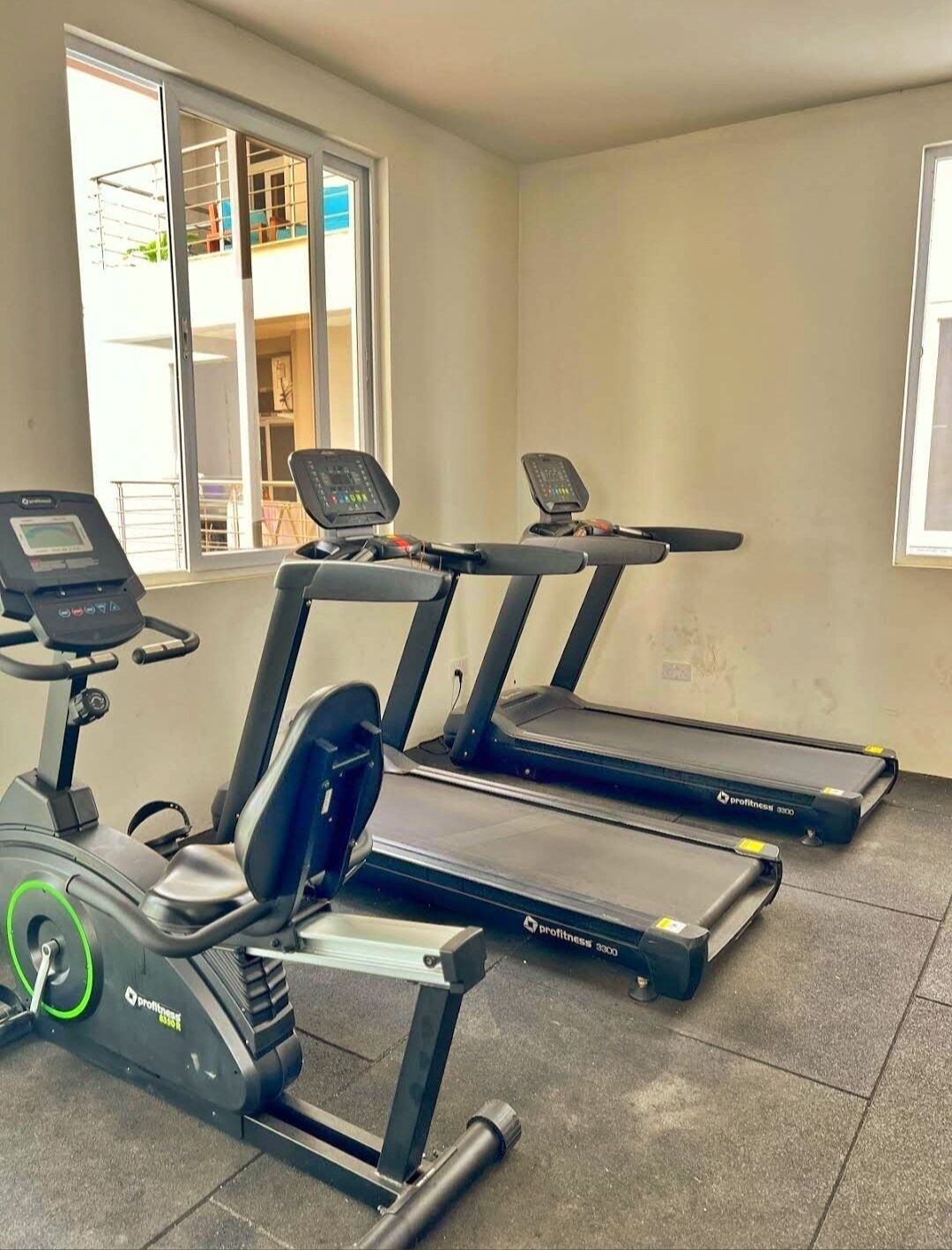 A gym with two treadmills and an elliptical machine.