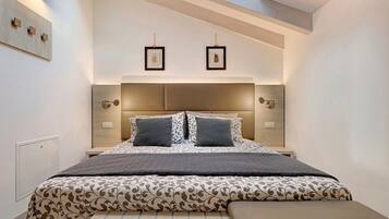 Een moderne slaapkamer met een groot bed, een bankje en een dakraam.