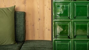 Ein Zimmer mit einer Holzwand, einem grünen Schrank und einem grünen Sofa mit einem grünen Kissen.