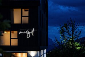 Un edificio con un letrero de neón que dice 'Mountain Lodge' y 'marjitt' durante la noche.