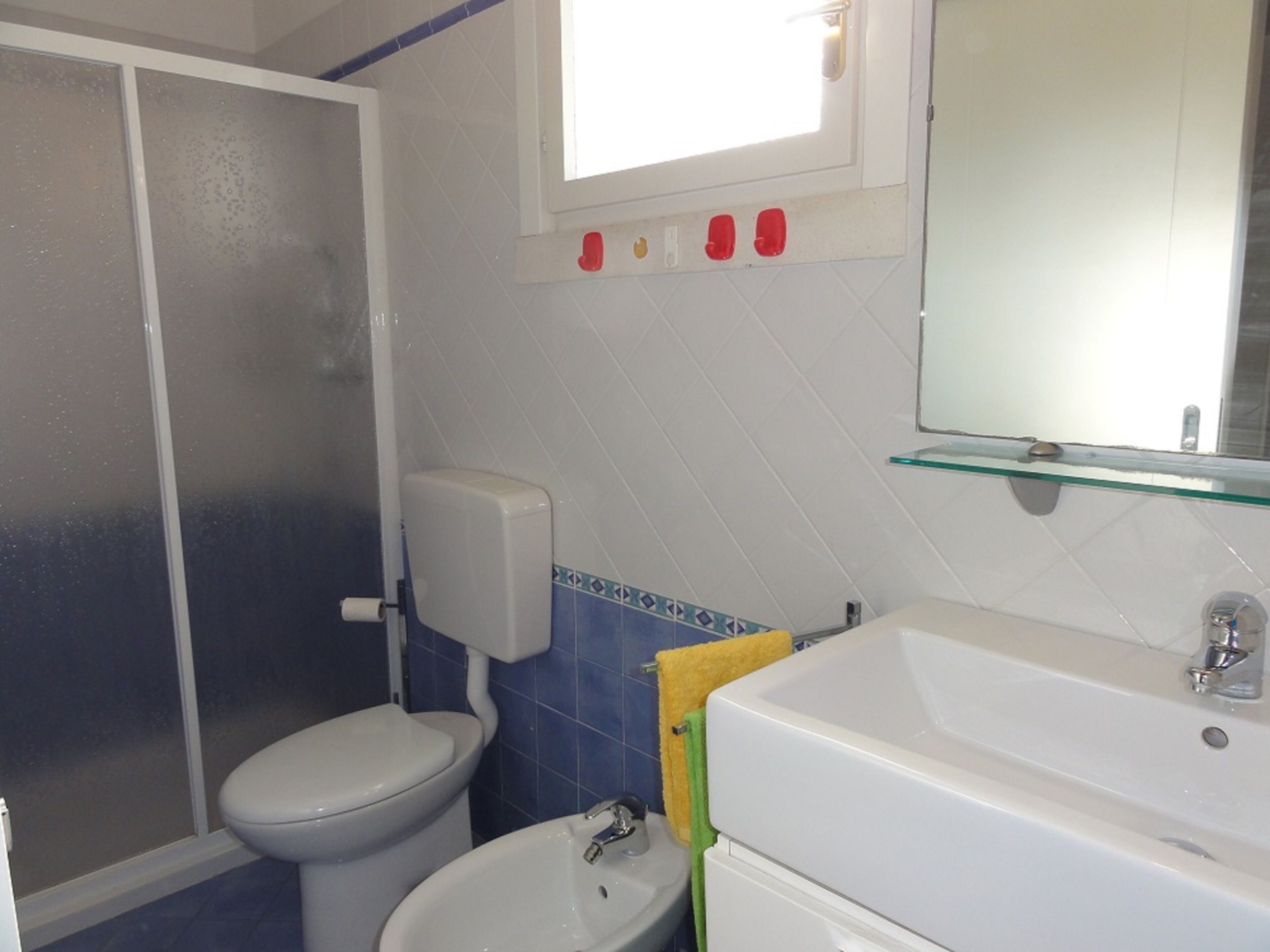 Een badkamer met toilet, bidet en wastafel.