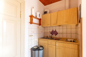 A kitchen with wooden cabinets, a sink, and a stove.