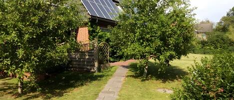 Een pad dat leidt naar een gebouw met zonnepanelen op het dak.
