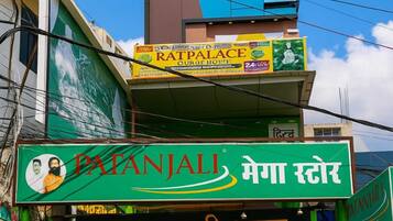 A multi-story building with a green facade and a signboard for 'Patanjali Mega Store'.