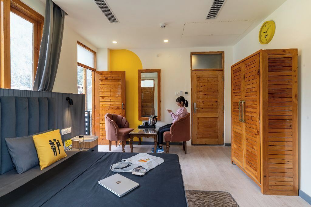 Una habitación de hotel moderna con una cama, un escritorio y dos sillas.