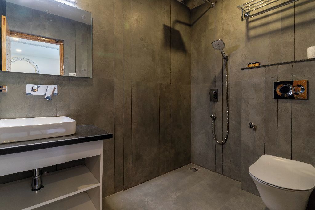 Un baño con un lavamanos blanco, un espejo, una ducha y un inodoro.