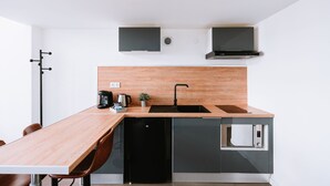 A modern kitchen with a wooden countertop, black appliances, and a built-in microwave.
