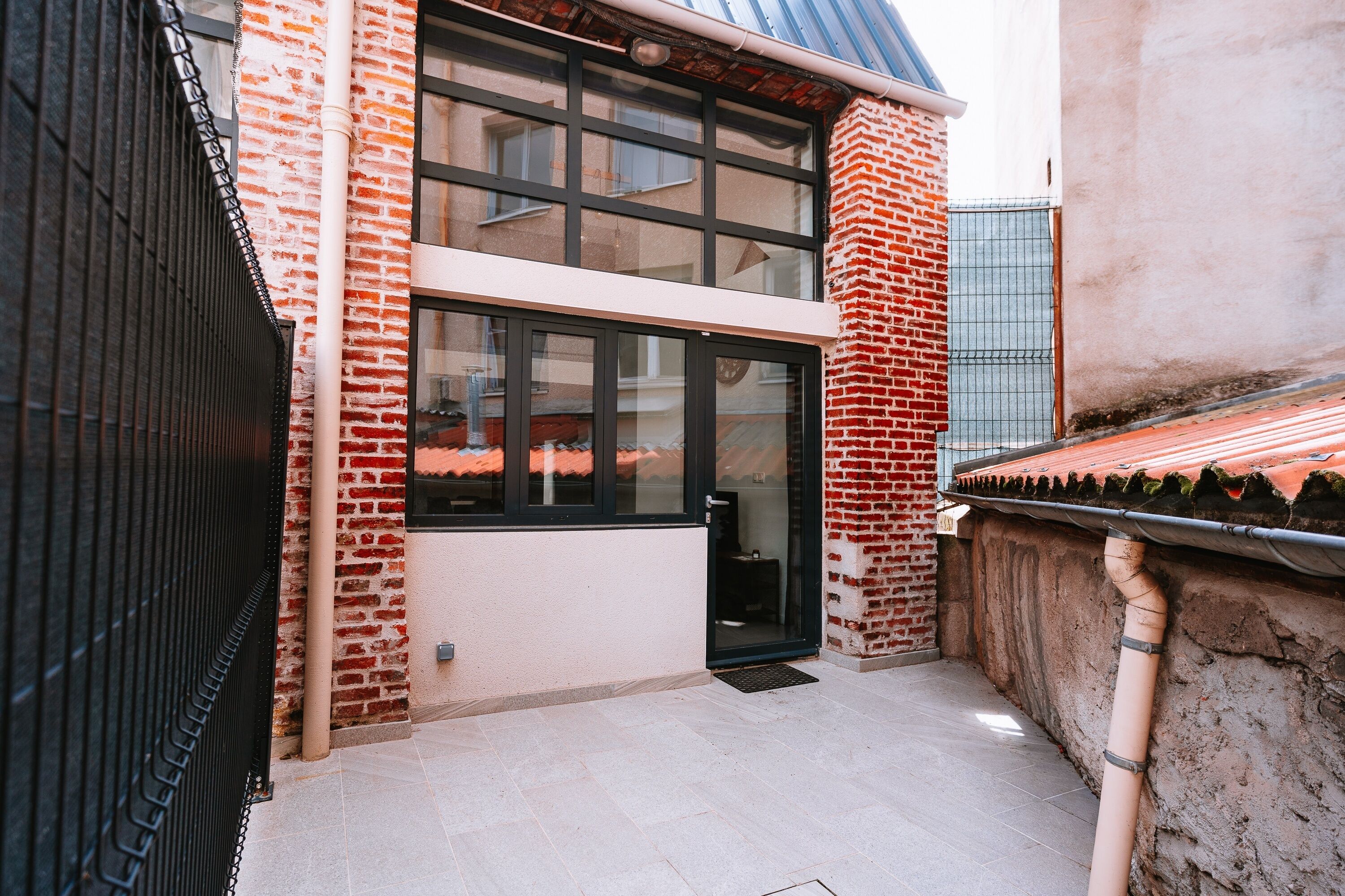 Un bâtiment moderne avec une façade en briques, de grandes fenêtres et un toit plat.