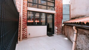 A modern building with a brick facade, large windows, and a flat roof.