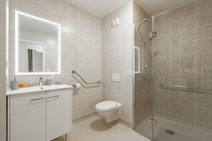 A modern bathroom with a toilet, sink, and shower. - Résidence de Chelles (Chelles)