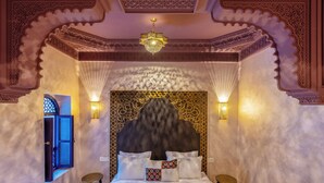A room with a bed, two nightstands, a decorative ceiling, and a wall with intricate patterns. - Palais Andara Riad And SPA (Marrakech)