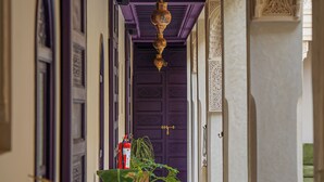 A corridor with purple doors and hanging lanterns. - Palais Andara Riad And SPA (Marrakech)