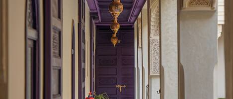 A corridor with purple doors and hanging lanterns.