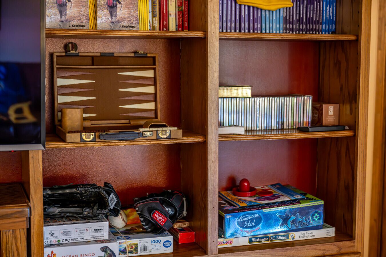 A bookshelf with various items including books, a board game, and a model train set.