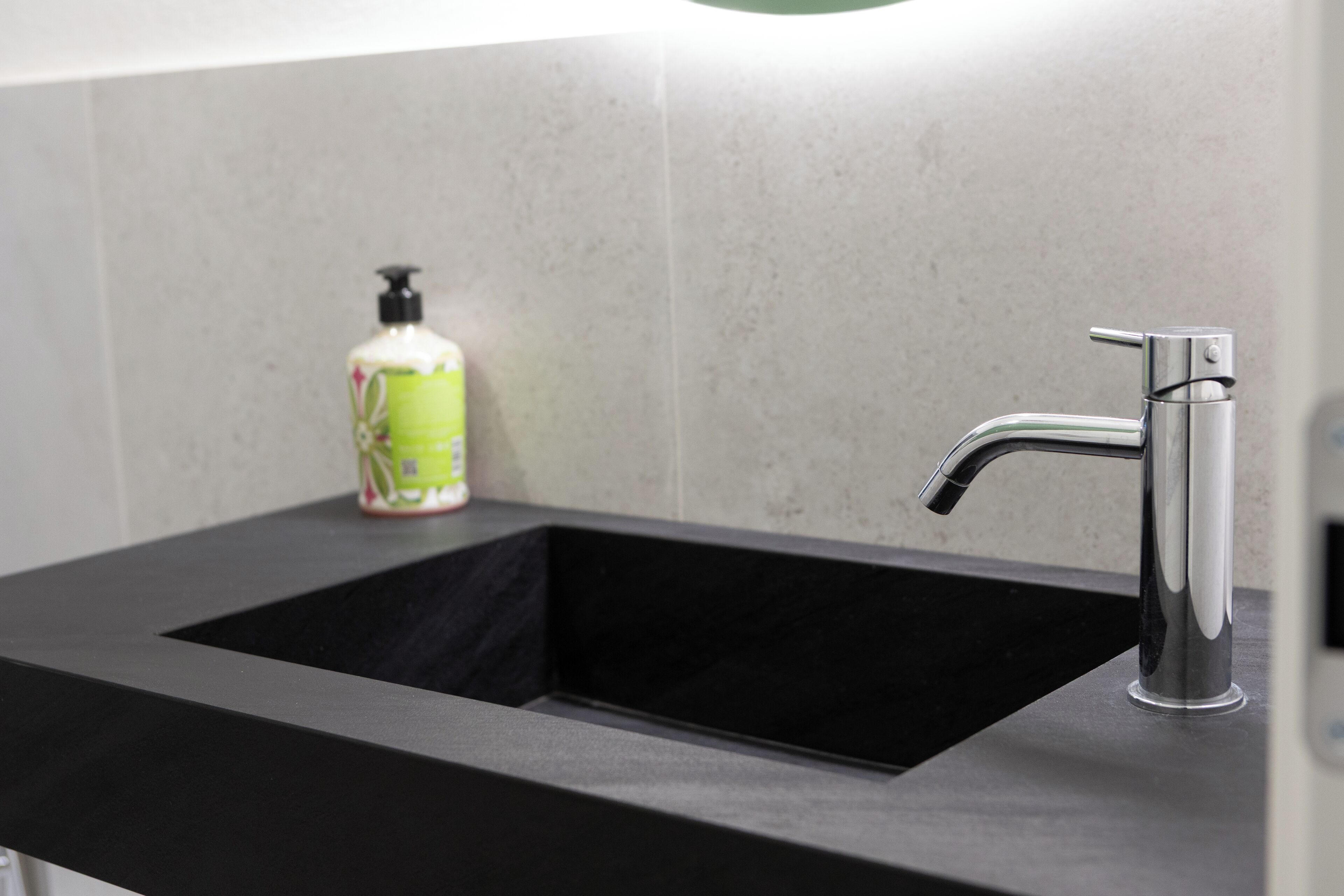 Une salle de bain moderne avec un lavabo noir et un robinet chromé.