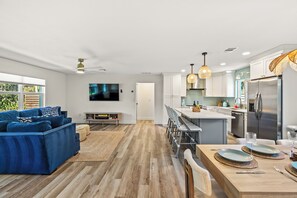 A modern kitchen with a central island, stainless steel appliances, and pendant lighting.