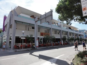 Un immeuble à plusieurs étages doté d’une terrasse et d’une enseigne indiquant la présence d’un restaurant.