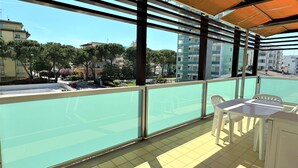 A balcony with a view of a residential area, including buildings and trees. - Bright Apartment Near the Beach (San Michele al Tagliamento)