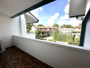 A balcony with a view of a residential area, including houses and greenery. - Nice Two-storey Flat (San Michele al Tagliamento)