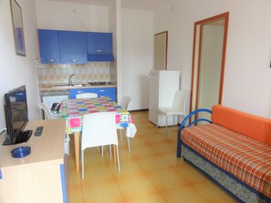 A compact living space with a kitchenette, a dining area, and a sofa. - Cozy Flat in a Villa With Garden (San Michele al Tagliamento)