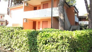 Ein zweistöckiges Gebäude mit Flachdach und einem Balkon im oberen Geschoss.