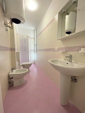 A bathroom with a toilet, bidet, and sink. - Modern Apartment in Central Location (San Michele al Tagliamento)
