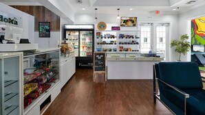 Ein modernes Café-Interieur mit einer Kaffeemaschine, einer Kühlvitrine und einer Theke mit verschiedenen Artikeln.