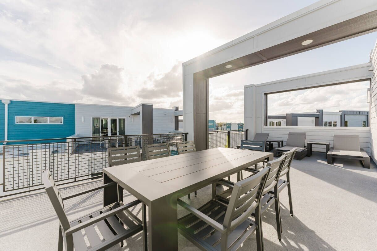 Une terrasse sur le toit, avec une table et des chaises pour les repas, un coin salon et une vue sur le paysage urbain.
