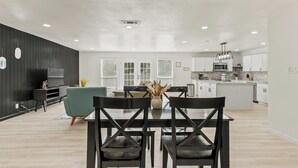 Una cocina moderna con armarios blancos, un microondas y una cafetera.
