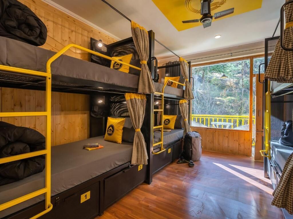 Habitación tipo dormitorio con literas, ventilador de techo y vistas al exterior.