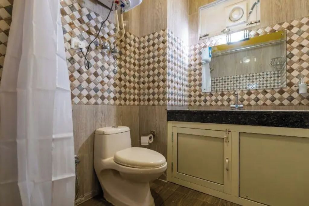 Un baño con inodoro, lavamanos y espejo.