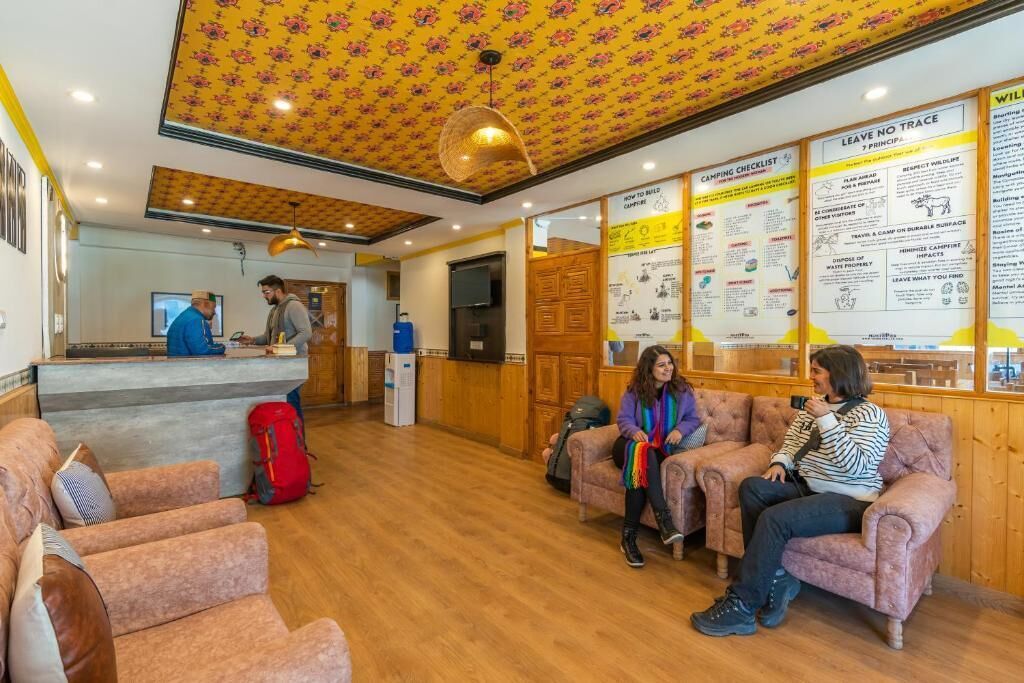 Un espace d ’accueil doté de parquets en bois, de sièges confortables et de panneaux d’information affichés sur les murs.